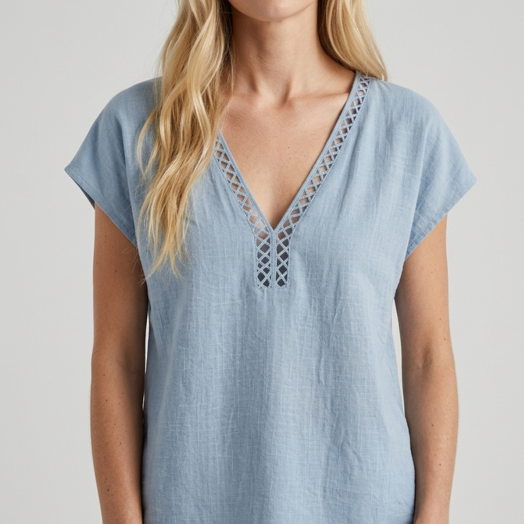 A woman wearing a light blue short-sleeve linen top with a V-neck and lace-up front detail, shown against a neutral light gray background.